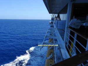 Port side view of ship at sea with water breaking to the left side - Solo Cruising